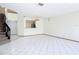 Expansive living area with white tile flooring, staircase, and an open view to the kitchen at 509 Lake Bridge Dr, Ormond Beach, FL 32174