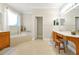 Bright bathroom featuring a soaking tub beneath a window and wood cabinets at 5808 Oak Lake Trl, Oviedo, FL 32765