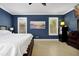 Navy bedroom featuring a large bed, white shutters, wood dresser, and modern decor at 5808 Oak Lake Trl, Oviedo, FL 32765