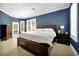 Primary bedroom with dark blue walls, white trim, and a large bed with storage drawers at 5808 Oak Lake Trl, Oviedo, FL 32765