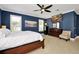 Primary bedroom featuring a bed, ceiling fan, white shutters, and an entertainment center at 5808 Oak Lake Trl, Oviedo, FL 32765
