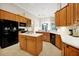 Spacious kitchen featuring an island, stainless appliances, light countertops, and wood cabinets at 5808 Oak Lake Trl, Oviedo, FL 32765