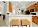 Bright kitchen features light countertops, wooden cabinets, rattan stools, and stainless steel appliances at 5808 Oak Lake Trl, Oviedo, FL 32765