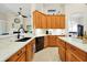 Well-lit kitchen featuring wood cabinets, white countertops, black appliances, and a stainless steel sink at 5808 Oak Lake Trl, Oviedo, FL 32765