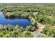 A tranquil lake is seen in an aerial view of a community surrounded by lush trees and serene walking paths at 5808 Oak Lake Trl, Oviedo, FL 32765
