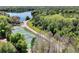 Aerial view of community tennis courts surrounded by green trees, with a serene lake in the background at 5808 Oak Lake Trl, Oviedo, FL 32765