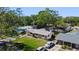 An aerial view of the single-story home with a well-maintained lawn and lush surrounding trees at 614 Johnson Dr, Ormond Beach, FL 32174