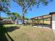Lush backyard features a covered patio, storage shed, and mature shade trees at 614 Johnson Dr, Ormond Beach, FL 32174