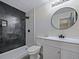 This remodeled bathroom offers a tiled walk-in shower and a modern vanity with an oval mirror at 614 Johnson Dr, Ormond Beach, FL 32174