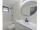 Stylish bathroom features a shower-tub combo, a sleek vanity, and a modern round mirror at 614 Johnson Dr, Ormond Beach, FL 32174