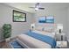 Bright bedroom features a ceiling fan, plush bed, and serene beach artwork, creating a tranquil atmosphere at 614 Johnson Dr, Ormond Beach, FL 32174