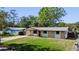 Charming single-story home featuring stone accents, a covered porch, and a well-manicured lawn at 614 Johnson Dr, Ormond Beach, FL 32174