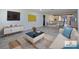 Staged living room with modern furniture, neutral tones, and open floor plan into dining area at 614 Johnson Dr, Ormond Beach, FL 32174
