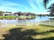 Serene backyard with manicured lawn and water view featuring homes in the distance at 6794 Calistoga Cir, Port Orange, FL 32128