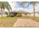 Backyard featuring tropical foliage, brick patio and partial view of screened lanai at 6794 Calistoga Cir, Port Orange, FL 32128