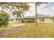 Expansive backyard with brick patio, palm trees, grass and view of screened in lanai at 6794 Calistoga Cir, Port Orange, FL 32128