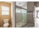 Bathroom with glass shower, window, toilet and tan walls at 6794 Calistoga Cir, Port Orange, FL 32128