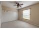 Bright bedroom with neutral carpet, ceiling fan, window with blinds and white accent wall at 6794 Calistoga Cir, Port Orange, FL 32128