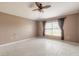Spacious bedroom featuring tile floors, large window with curtains and a ceiling fan at 6794 Calistoga Cir, Port Orange, FL 32128