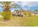 Well-maintained home featuring lush landscaping, mature palm trees, and a beautifully manicured lawn at 6794 Calistoga Cir, Port Orange, FL 32128
