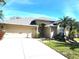 Charming single-story home with a two-car garage, tropical landscaping, and inviting curb appeal at 6794 Calistoga Cir, Port Orange, FL 32128