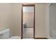 Bright bathroom featuring a toilet, shower, and a view into an attached room at 7 Appaloosa Trl, Ormond Beach, FL 32174