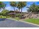 Exterior view of a building with wood accents, a staircase, and lush landscaping with palm trees at 7 Appaloosa Trl, Ormond Beach, FL 32174