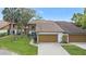Charming home showcasing a two-car garage, well-maintained lawn, and mature landscaping at 7 Appaloosa Trl, Ormond Beach, FL 32174