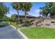Exterior view of a building with wood accents, a staircase, and lush landscaping with palm trees at 7 Appaloosa Trl, Ormond Beach, FL 32174