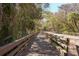 Inviting wooden bridge surrounded by mature trees and lush foliage at 7 Appaloosa Trl, Ormond Beach, FL 32174