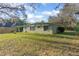 A large green lawn surrounds this charming light green home, offering a serene outdoor space at 782 Valencia Ave, Orange City, FL 32763