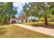 Wide angle shot showing the home and long driveway with ample parking, mature trees, and an attached one-car garage at 816 Overhill Rd, Deland, FL 32720