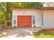 Exterior view of the garage showcasing its bright orange door and minimalist design at 816 Overhill Rd, Deland, FL 32720