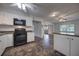 Bright kitchen with white cabinets, black appliances, tile backsplash and laminate countertops at 816 Overhill Rd, Deland, FL 32720