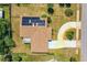Aerial view of the rooftop that features solar panels, the driveway, and fenced-in yard at 863 Riverside Dr, Ormond Beach, FL 32176