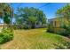 Spacious backyard featuring a well-maintained lawn, privacy fence, mature landscaping, and a screened porch at 863 Riverside Dr, Ormond Beach, FL 32176