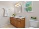 Bathroom with a single vanity, decorative mirror and lighting, and window with natural light at 863 Riverside Dr, Ormond Beach, FL 32176