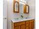 Bathroom featuring double sinks, white countertop, wood cabinets and vanity lighting at 863 Riverside Dr, Ormond Beach, FL 32176