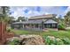 View of the backyard, showcasing an enclosed pool, mature landscaping, and lush lawn at 1 Fox Hollow Dr, Ormond Beach, FL 32174