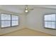 Bright bedroom with vaulted ceilings, fan and two windows at 1 Fox Hollow Dr, Ormond Beach, FL 32174