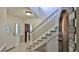 Inviting entryway featuring tile flooring and a staircase with stone accent wall at 1 Fox Hollow Dr, Ormond Beach, FL 32174