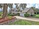 Charming two-story brick home with a well-manicured lawn, lush landscaping and mature trees at 1 Fox Hollow Dr, Ormond Beach, FL 32174