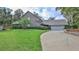Charming two-story brick home with mature landscaping and a curved driveway leading to the two car garage at 1 Fox Hollow Dr, Ormond Beach, FL 32174