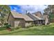 Rear view of the home showcasing the well-maintained lawn, mature landscaping, and architectural details at 1 Fox Hollow Dr, Ormond Beach, FL 32174