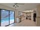 Well-lit kitchen featuring stainless steel appliances, light countertops, and sliding door access to the pool at 1 Fox Hollow Dr, Ormond Beach, FL 32174