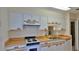 Kitchen features white cabinetry, wood countertops and white appliances at 1 Fox Hollow Dr, Ormond Beach, FL 32174