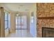 Cozy living room featuring a stone fireplace, tile floors, and sliding glass doors to the outdoor patio at 1 Fox Hollow Dr, Ormond Beach, FL 32174
