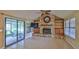 Living room with a large stone fireplace, sliding glass doors to the lanai, and tile floors at 1 Fox Hollow Dr, Ormond Beach, FL 32174