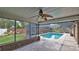 Covered patio features brick flooring and a fan, leading to a screened pool area at 1 Fox Hollow Dr, Ormond Beach, FL 32174