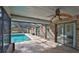 A view of the covered patio of brick flooring with a fan leading to the outdoor pool at 1 Fox Hollow Dr, Ormond Beach, FL 32174
